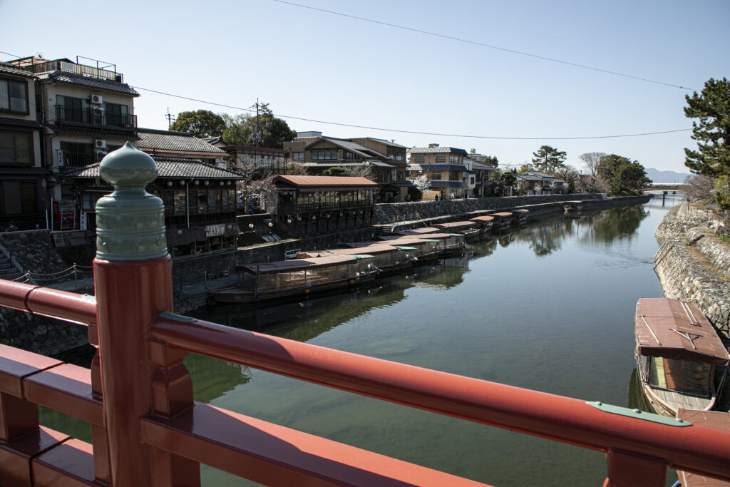 A bridge over water with covered boats near it